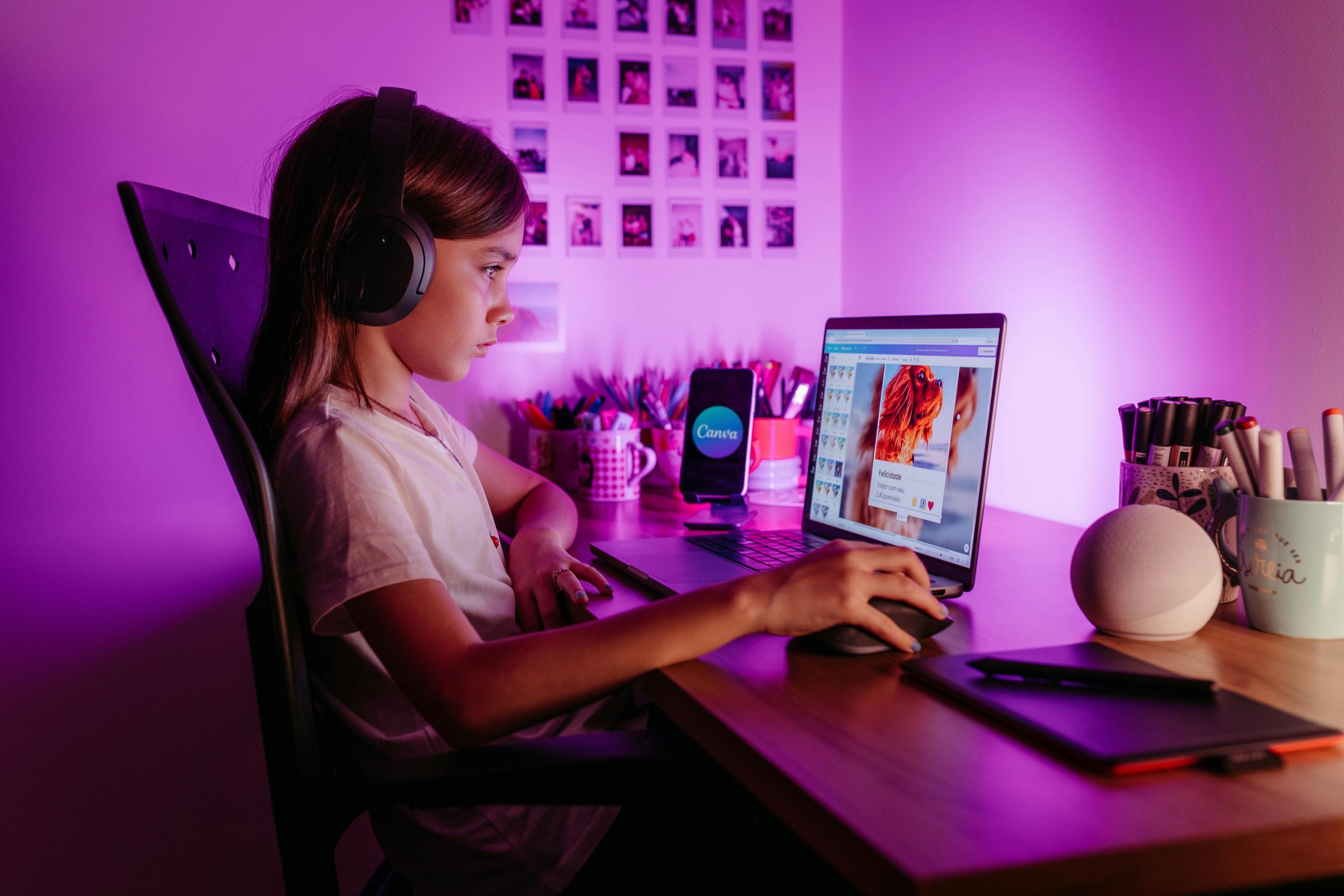 Anak-anak belajar coding dan AI menggunakan laptop dalam ruangan yang kreatif dan diterangi cahaya ungu.